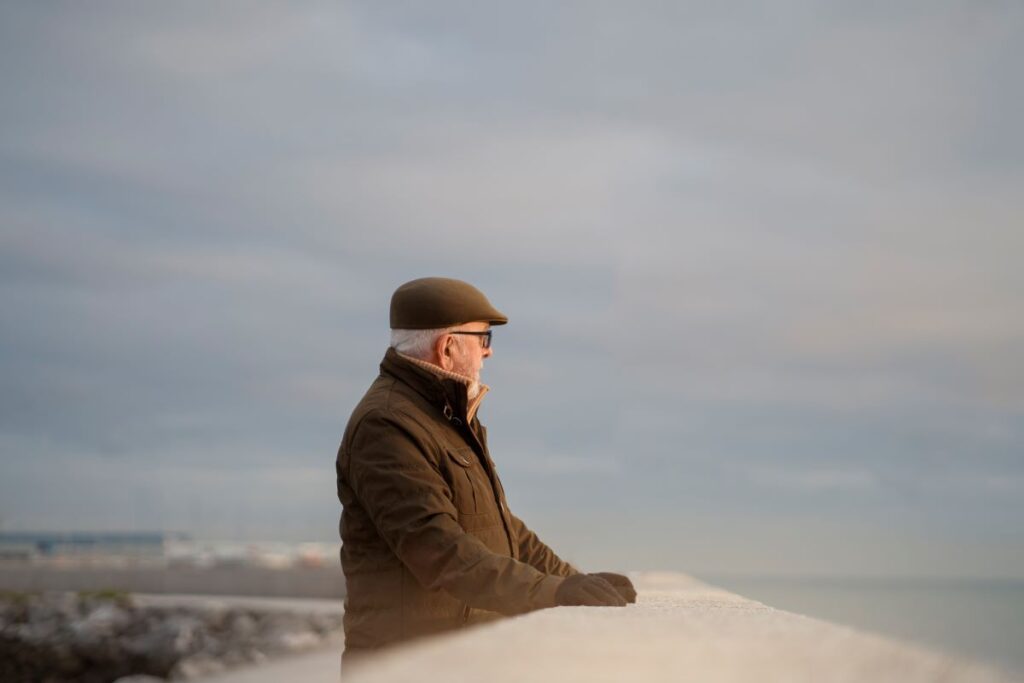 An elderly man gazing at the ocean, reflecting and defining a life worth living.